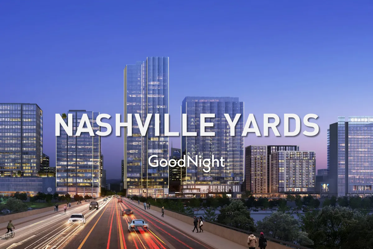 A vibrant cityscape featuring gleaming skyscrapers, illuminated roadways, and city lights. The scene depicts a lively downtown area, ideal for both business meetings and evening leisure activities.